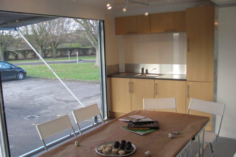 Interior of outreach unit with table and kitchen unit