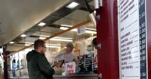 male customer waiting to be served at a burger van trailer