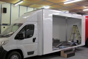 a chassis cab vehicle in build showing a box body with side cut out
