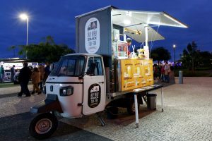 a small food truck with counter open in a dark evening
