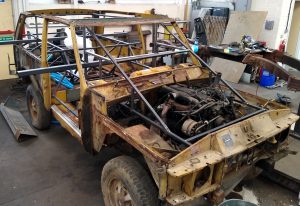 stripped down rusting shell of a land rover before being rebuilt