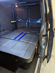 van seating converted into a bed in a camper van