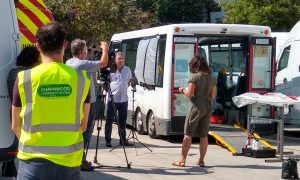 news team filming a minibus being repaired