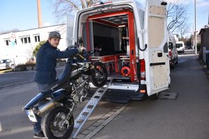 motorcycle being pushed up a ramp into the pod