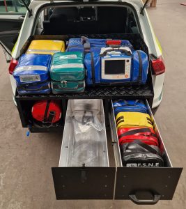 Equipment drawers sliding out of the rear of a Volvo SUV filled with medical equipment used as an incident response vehicle