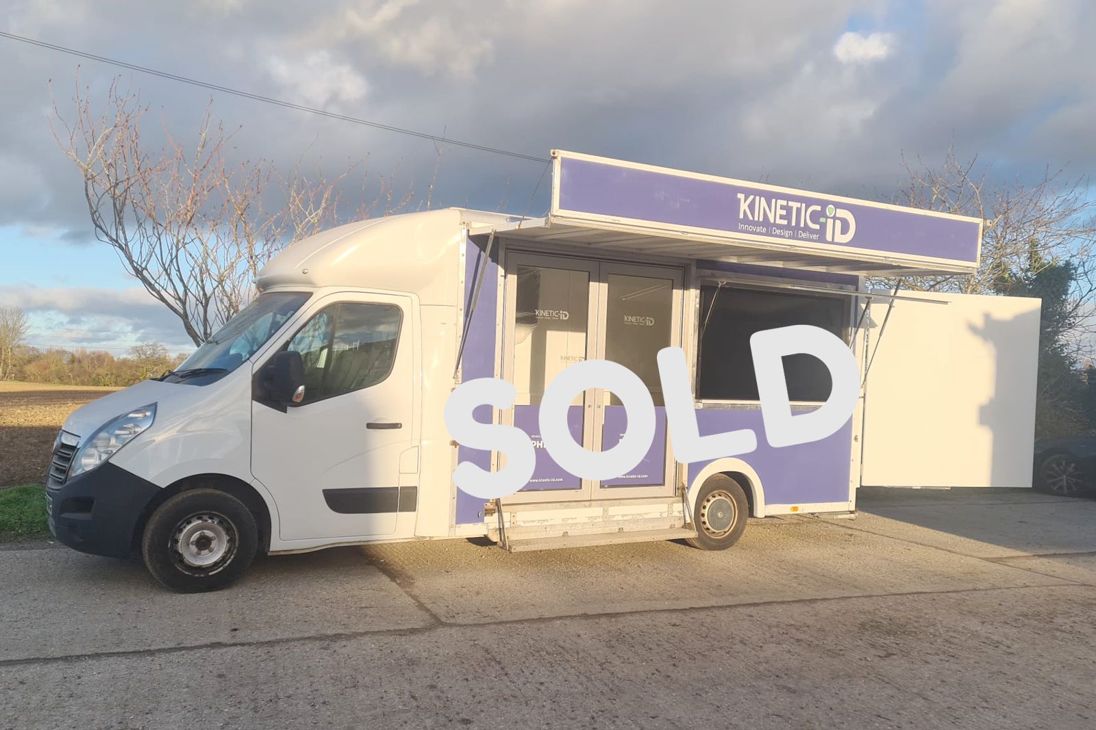 chassis cab exhibition vehicle nearside view.. Dark cloudy sky. A sold label is placed across the photo