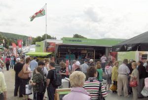 Crowds of people in front of a country show stand.made from a 7 metre exhibition trailer
