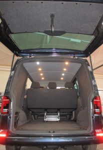 interior of an empty van in which the walls and ceiling have been van carpet lined in a light grey material