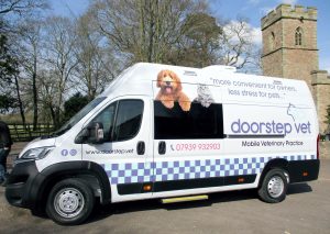 a mobile veterinary surgery from the front nearside showing a white van with a window in the side door