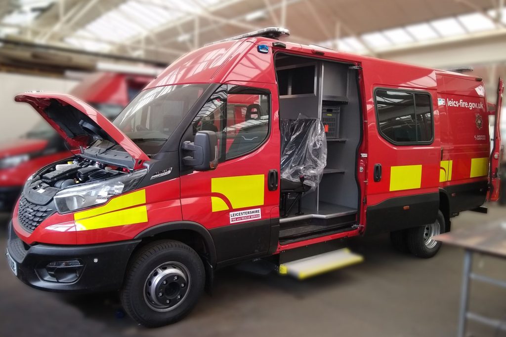 Van fitting out for a fire services showing a red van with side door open and seating having just been fitted. The bonnet is raised