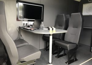 van fitting out which includes a table with additional seating installed. This view from the side door.