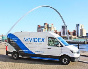The exterior view of a promotional van conversion parked alongside the River Tyne with the millenium bridge in the background.