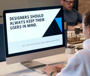 photo of a designers sitting at desk with a computer screen showing a message abour sensory design