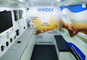 This is the interior of a van based product promotion roadshow vehicle showing a product display with small seating bench.