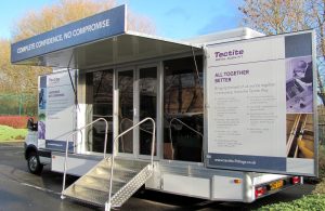 Exterior view of a product demonstration vehicle visiting plumbers merchants. It features two swing out display panels, glazed doors and a flight of access steps.