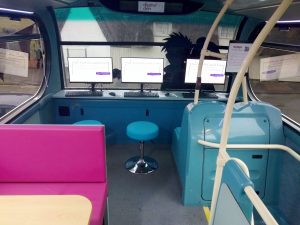 Interior of a youth bus showing three computer screens to create an IT den for youngsters.