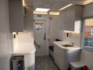 Interior view of an outreach vehicle providing mobile healthcare. The photo shows a seat and wash up area.