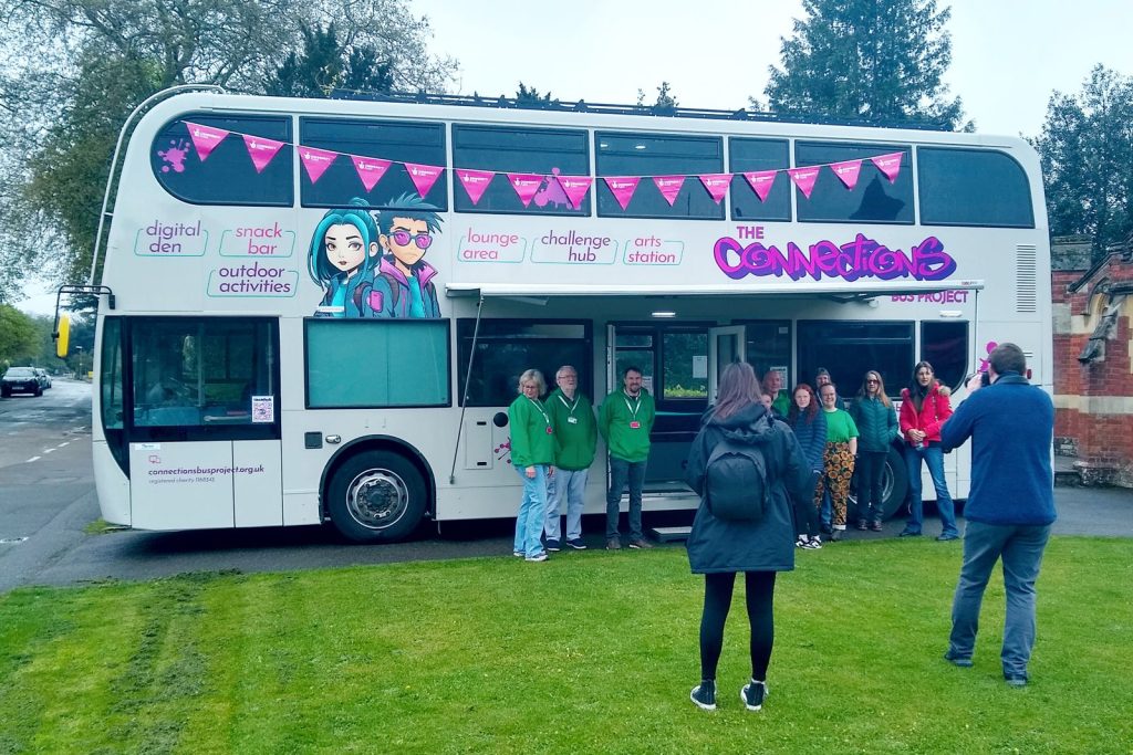 This youth club double deck bus conversion is painted in silver and features a rool out awning over the entrance door. This community support bu is designed to provide a mobile club for teenagers in rural areas.
