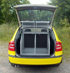 The rear view of a Skoda Octavia with rear tailgate open to show a specially designed dog cage